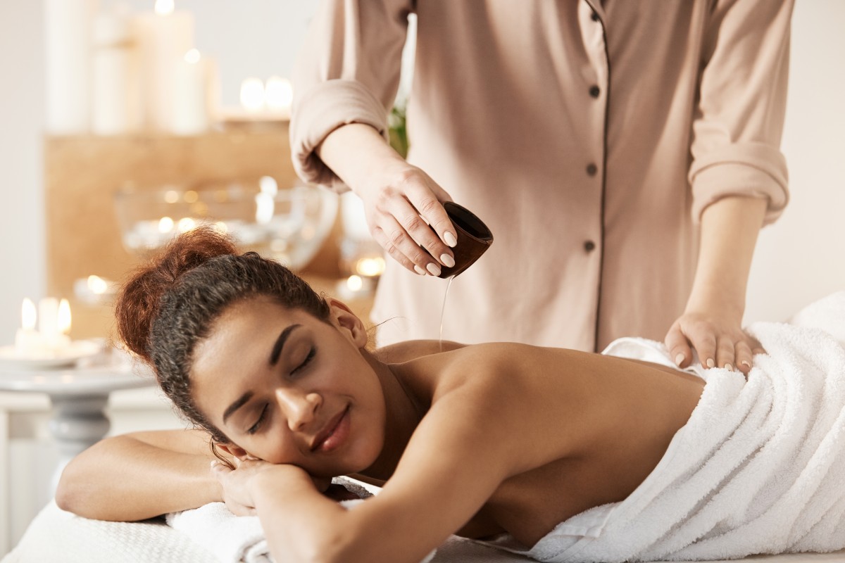 masseur-pouring-oil-doing-massage-beautiful-african-woman-spa-salon (1)