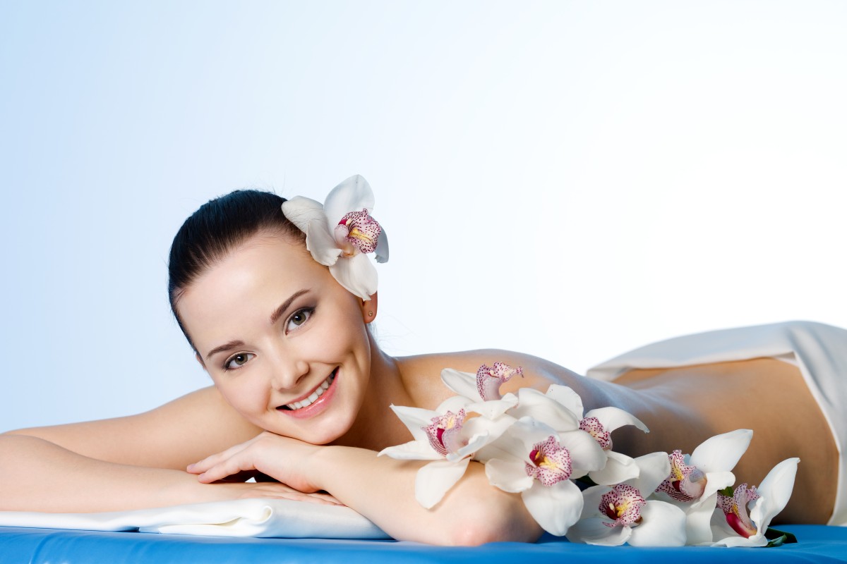 smiling-young-woman-with-flowers-resting-spa-salon-before-massage (1)